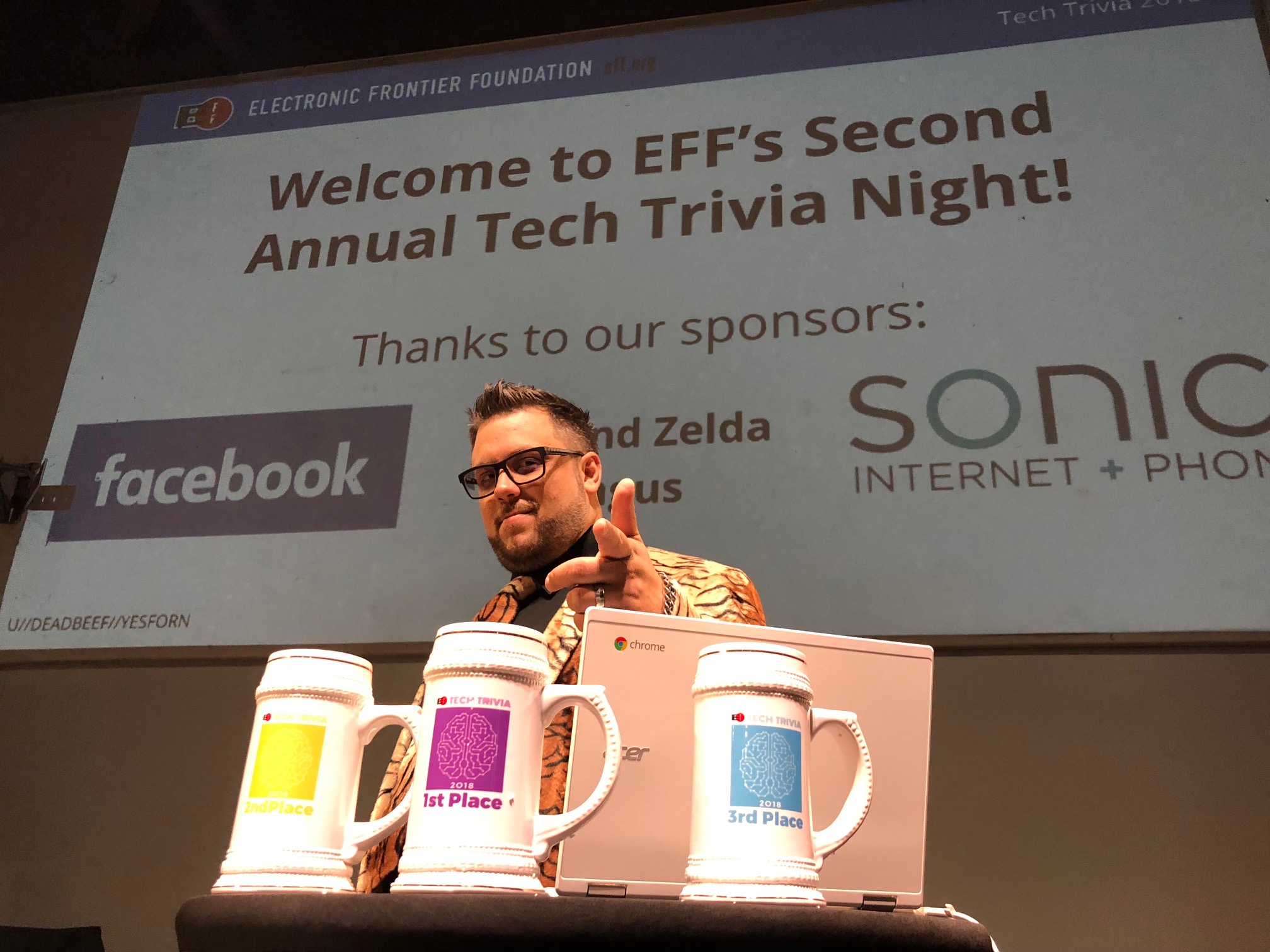 The Cybertiger, CooperQ, on-stage in front of a slide thanking our sponsors Bob and Zelda Angus, Facebook and Sonic