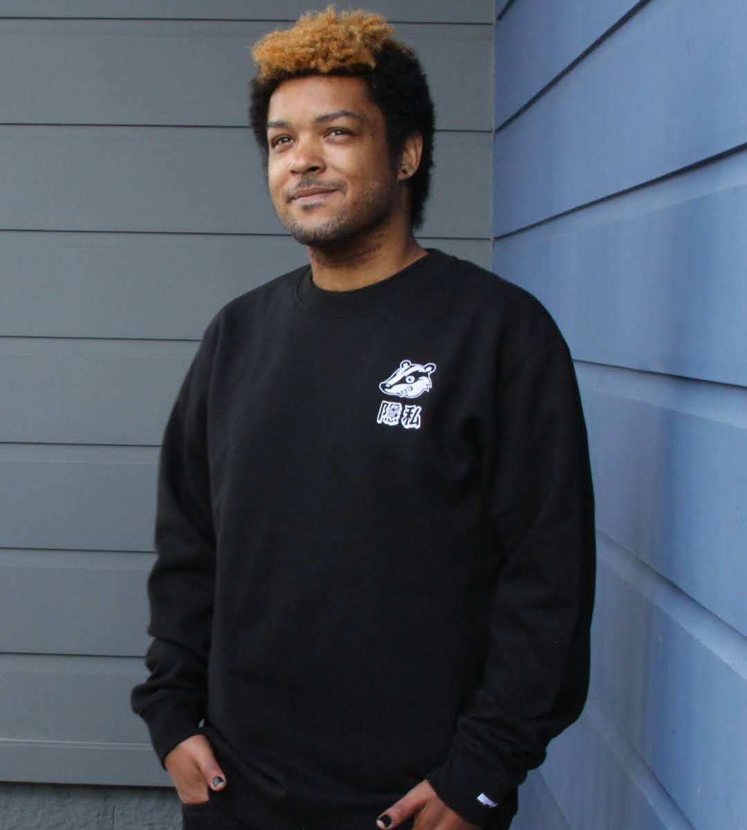 A person wearing a black sweatshirt with an embroidered Privacy Badger mascot on the chest over the characters for ‘privacy” in Traditional Chinese.